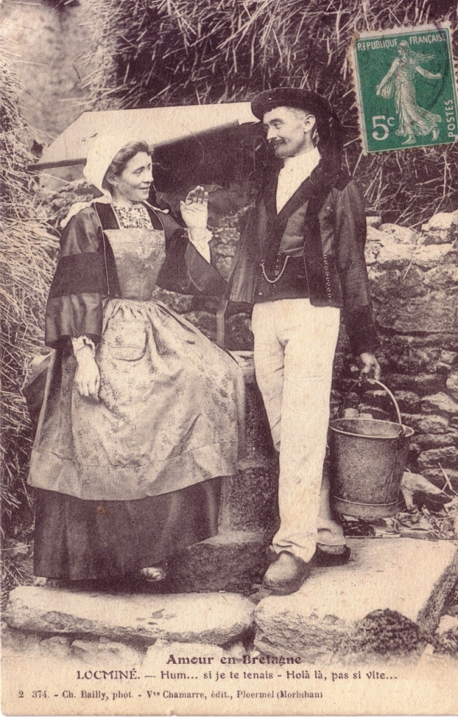 Une femme et un homme discutent à la fontaine, l'homme porte le costume de Baud et la femme porte le capot. (Locminé début XXème)
